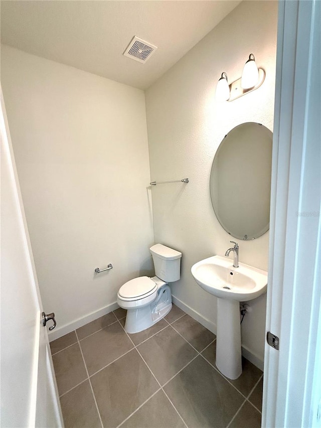 bathroom featuring tile patterned flooring, toilet, baseboards, and visible vents