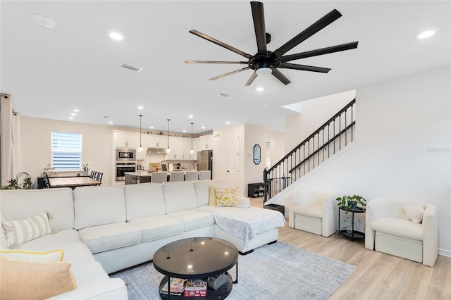 living room with ceiling fan and light hardwood / wood-style floors