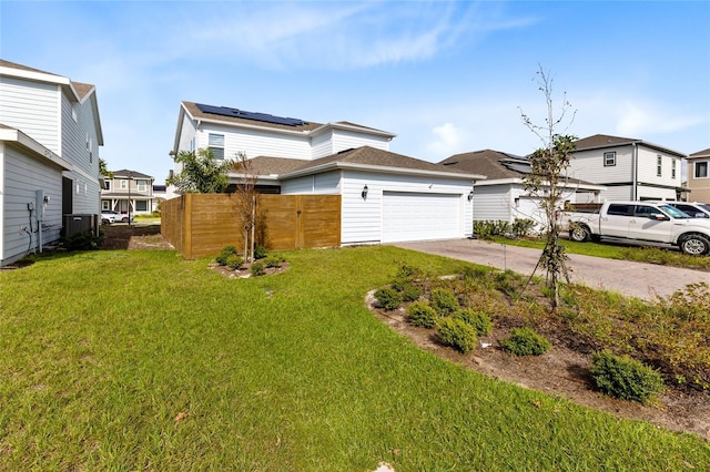 view of front of house with solar panels, a garage, and a front lawn