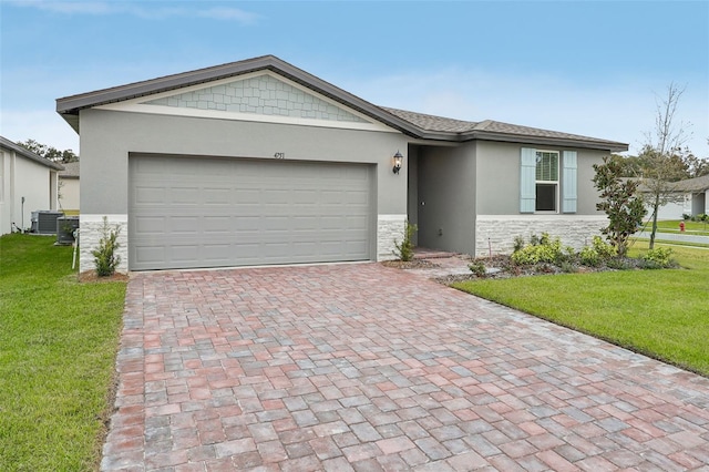 ranch-style house featuring a front yard, a garage, and central AC unit