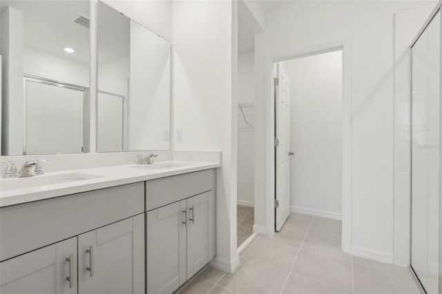 bathroom featuring tile patterned flooring, vanity, and a shower with door