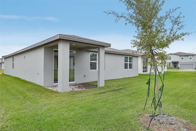 rear view of house featuring a yard and a patio area