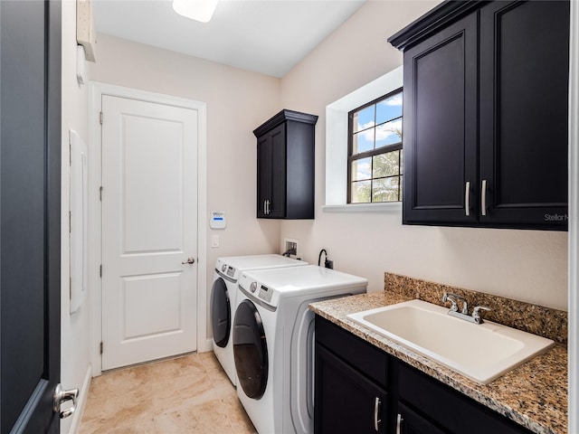 washroom with cabinets, washing machine and dryer, and sink