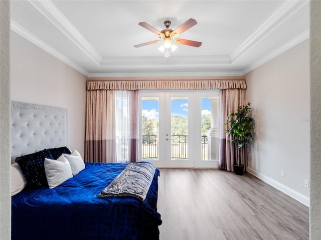 bedroom featuring access to outside, a raised ceiling, hardwood / wood-style flooring, and ceiling fan