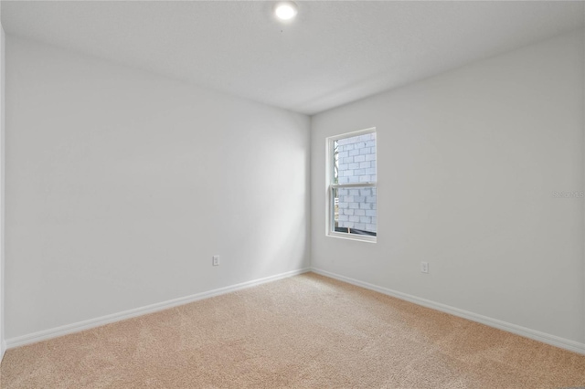 spare room featuring light colored carpet