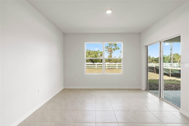 unfurnished room featuring light tile patterned floors and a wealth of natural light