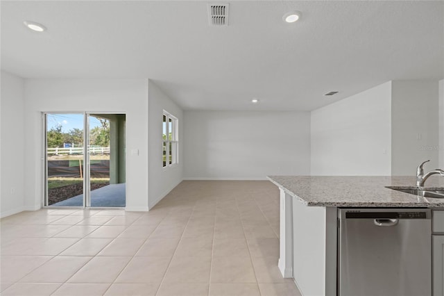 kitchen featuring light stone countertops, dishwasher, light tile patterned flooring, and sink