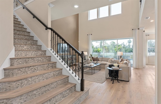 stairs featuring a towering ceiling and hardwood / wood-style flooring