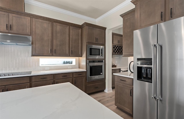 kitchen with decorative backsplash, stainless steel appliances, light hardwood / wood-style flooring, and ornamental molding