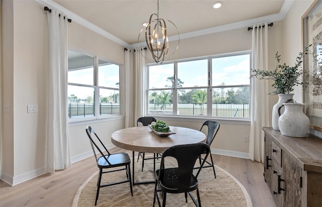 dining area with a chandelier, light hardwood / wood-style floors, and ornamental molding