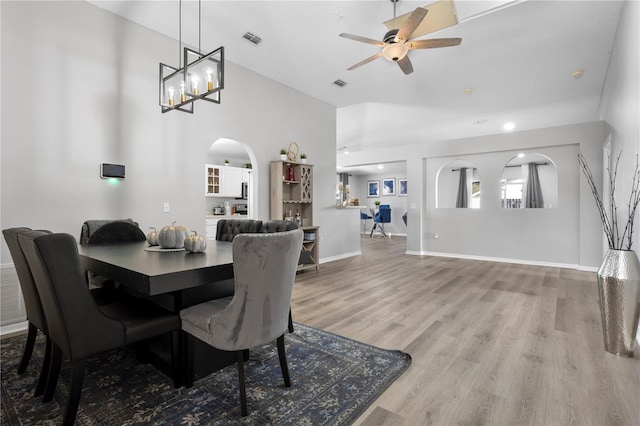 dining room featuring ceiling fan with notable chandelier and hardwood / wood-style flooring