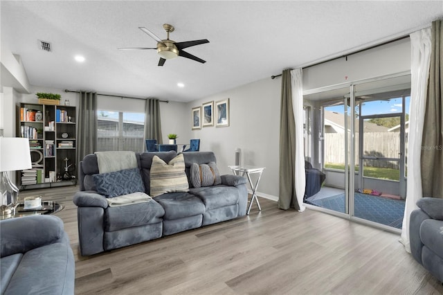 living room with ceiling fan, a healthy amount of sunlight, and light wood-type flooring