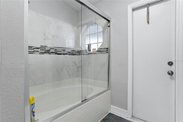 bathroom with combined bath / shower with glass door