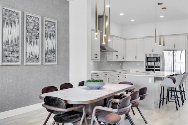 dining area featuring sink and light wood-type flooring