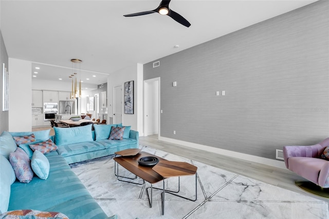 living room featuring ceiling fan and light hardwood / wood-style floors