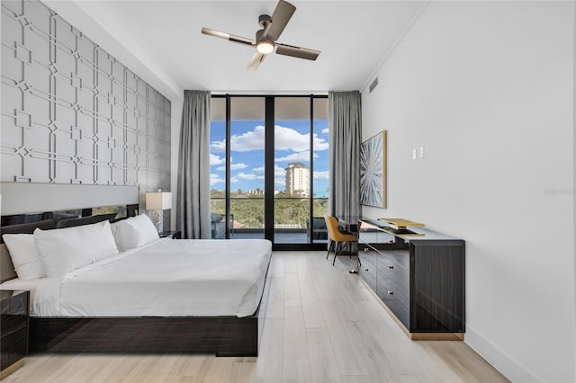 bedroom featuring access to exterior, light hardwood / wood-style floors, ceiling fan, and floor to ceiling windows