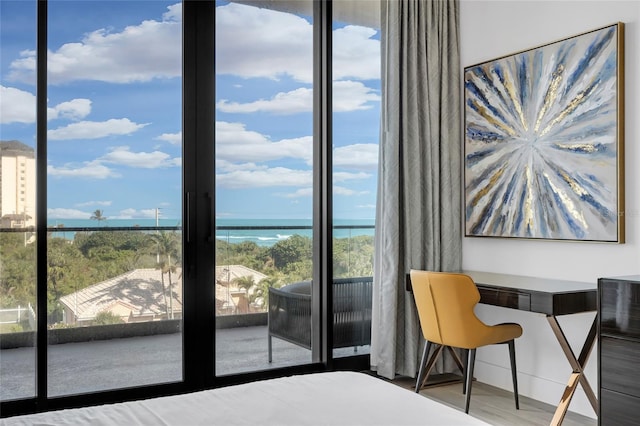 unfurnished bedroom featuring hardwood / wood-style floors, a water view, and multiple windows