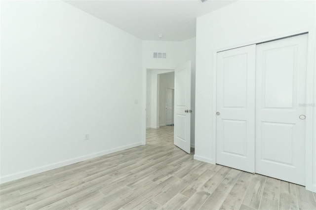 unfurnished bedroom featuring light hardwood / wood-style floors and a closet