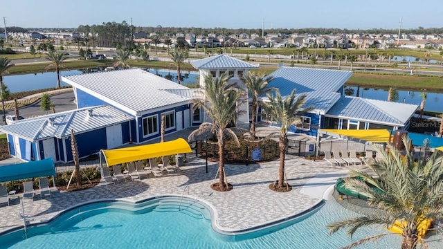 view of swimming pool featuring a water view and a patio