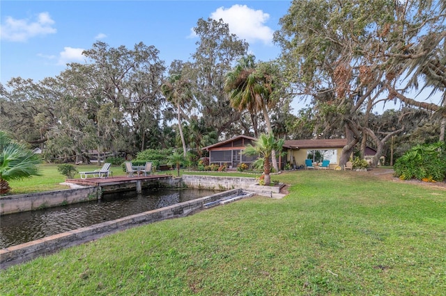 view of yard featuring a water view and a dock