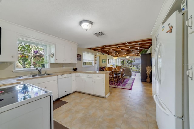 kitchen with white appliances, white cabinets, crown molding, sink, and kitchen peninsula