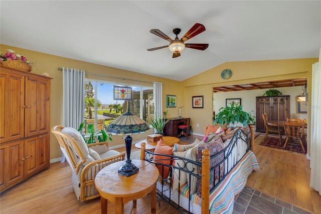 living room featuring ceiling fan, light hardwood / wood-style flooring, and lofted ceiling