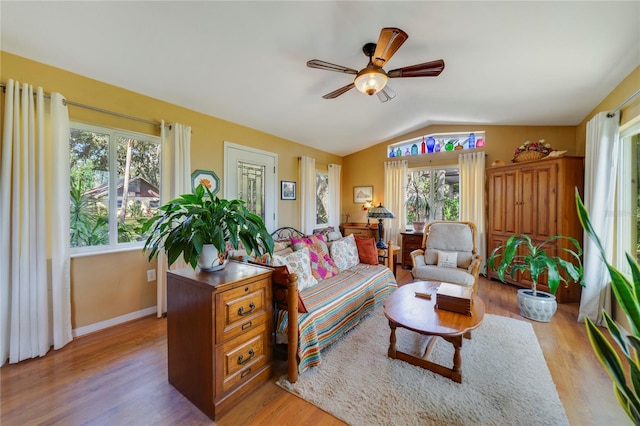 living room featuring light hardwood / wood-style flooring, a healthy amount of sunlight, and vaulted ceiling