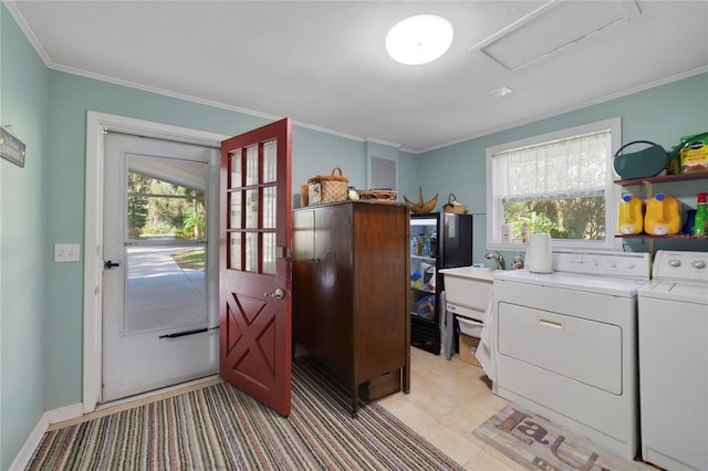 laundry area with light tile patterned floors, washing machine and dryer, and ornamental molding