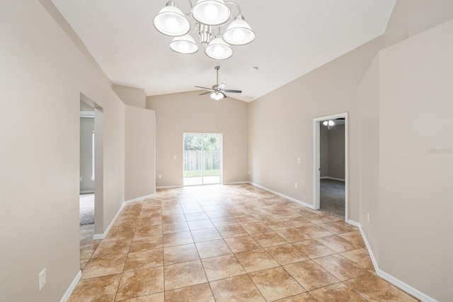 spare room featuring light tile patterned floors, ceiling fan with notable chandelier, and lofted ceiling