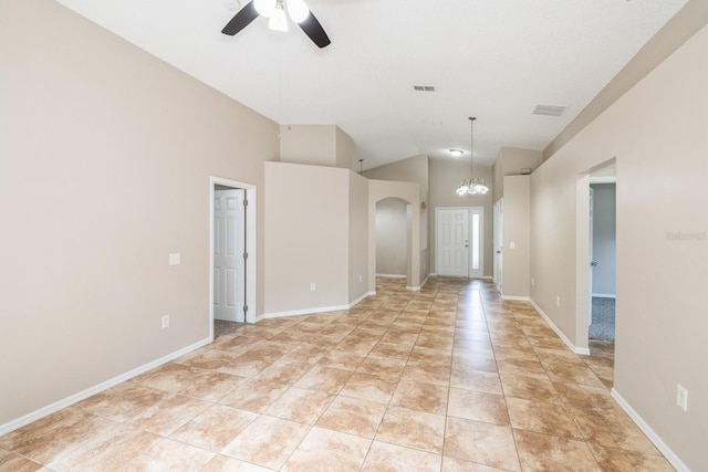 tiled empty room with high vaulted ceiling and ceiling fan with notable chandelier