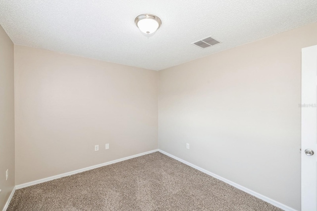 spare room with carpet floors and a textured ceiling