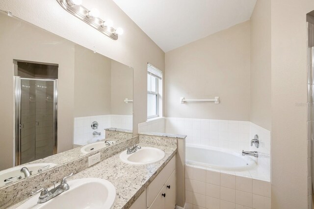 bathroom featuring vanity, separate shower and tub, and vaulted ceiling