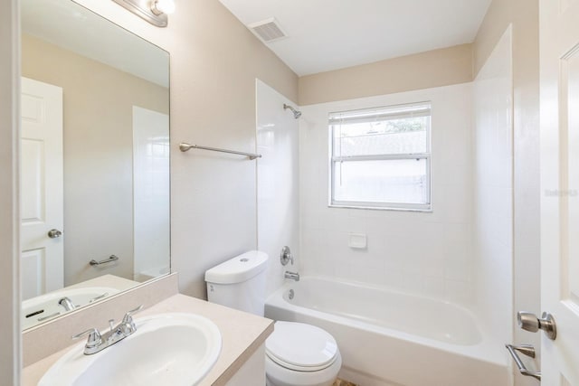 full bathroom featuring tiled shower / bath combo, toilet, and vanity