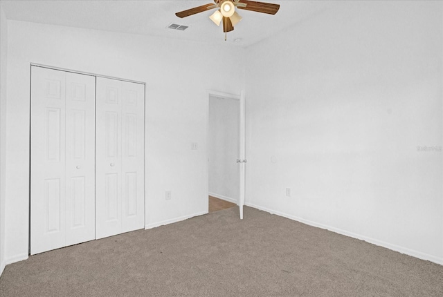 unfurnished bedroom featuring ceiling fan, a closet, carpet, and vaulted ceiling