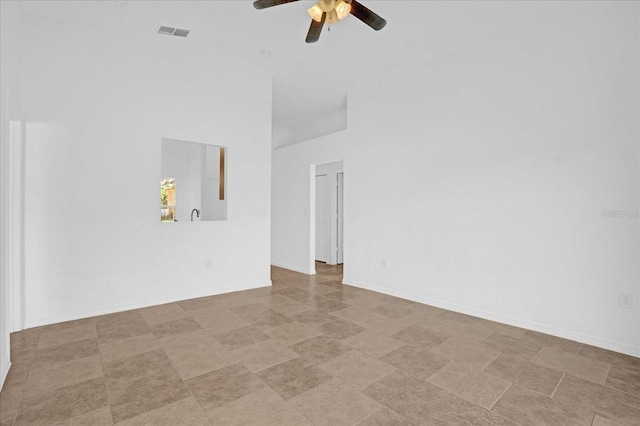 unfurnished room with ceiling fan and a towering ceiling