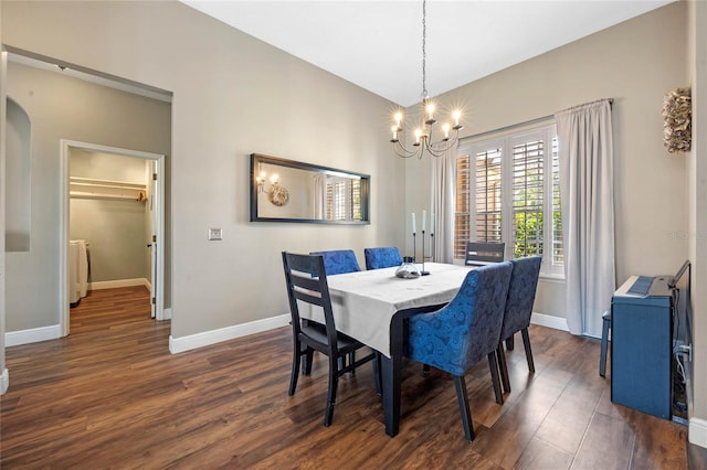 dining space featuring dark wood-type flooring, an inviting chandelier, and washing machine and dryer