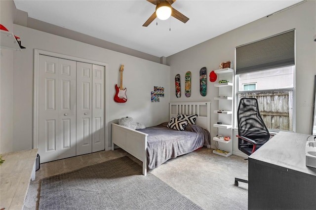 carpeted bedroom featuring ceiling fan and a closet