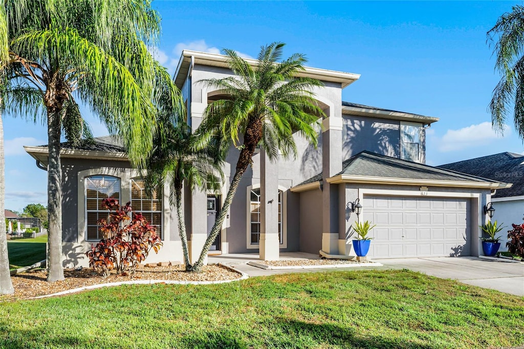 view of front of house with a front yard and a garage