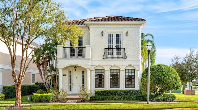 mediterranean / spanish home with a balcony and a front lawn