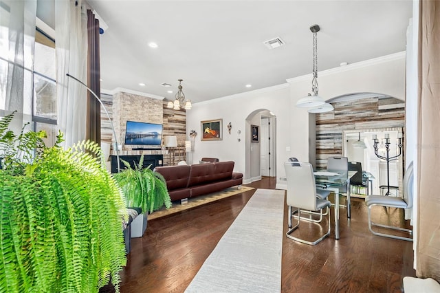 living room featuring crown molding, dark wood-type flooring, and a chandelier