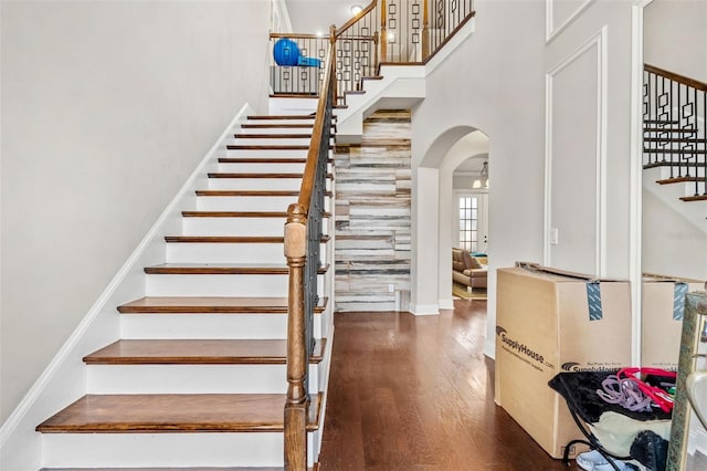 stairs featuring hardwood / wood-style floors and a high ceiling