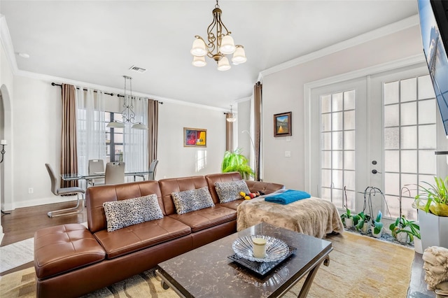 living room featuring hardwood / wood-style floors, ornamental molding, a wealth of natural light, and french doors