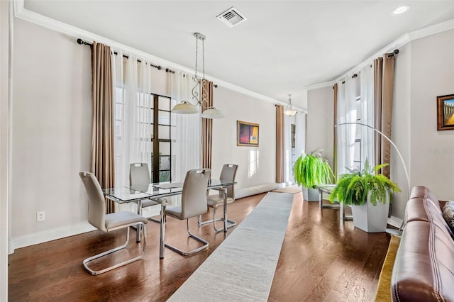 dining space with dark hardwood / wood-style floors and crown molding