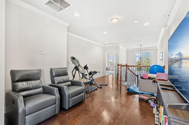 workout room featuring a chandelier, dark hardwood / wood-style floors, and ornamental molding