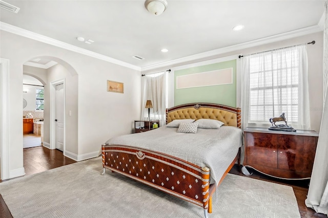 bedroom featuring ensuite bath, hardwood / wood-style floors, and ornamental molding