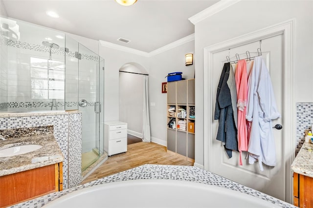 bathroom with wood-type flooring, vanity, shower with separate bathtub, and ornamental molding