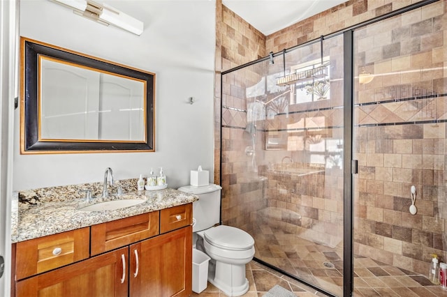 bathroom featuring tile patterned floors, vanity, toilet, and a shower with door