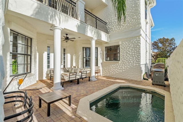 exterior space with ceiling fan, a balcony, an outdoor living space, and grilling area