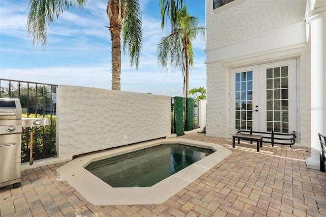 view of swimming pool featuring a patio area, a jacuzzi, and french doors