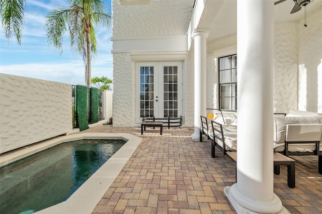 view of pool with french doors, a patio, and ceiling fan